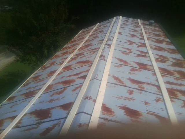 Rusted metal roof panels with new wood purlins before replacement — Storm Damage Roof Repair in Stanton by Roofing Brothers